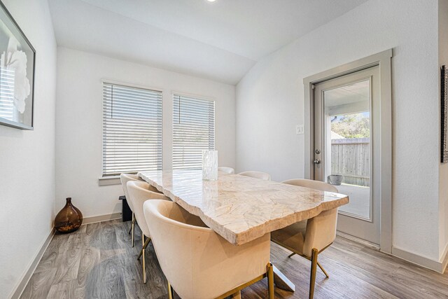 dining space with wood-type flooring and lofted ceiling