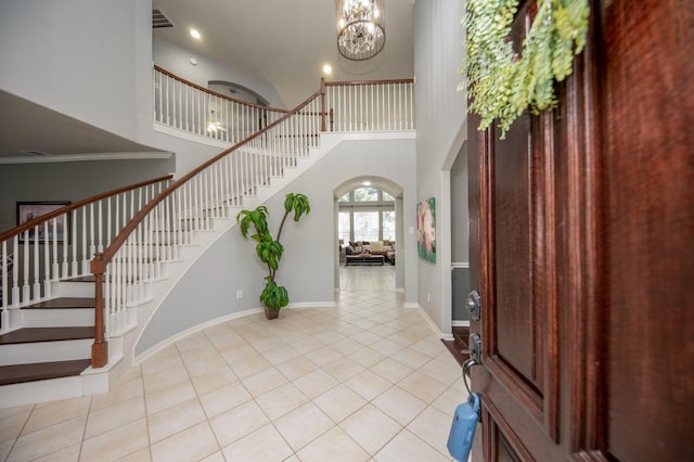 tiled entrance foyer featuring a chandelier and a towering ceiling