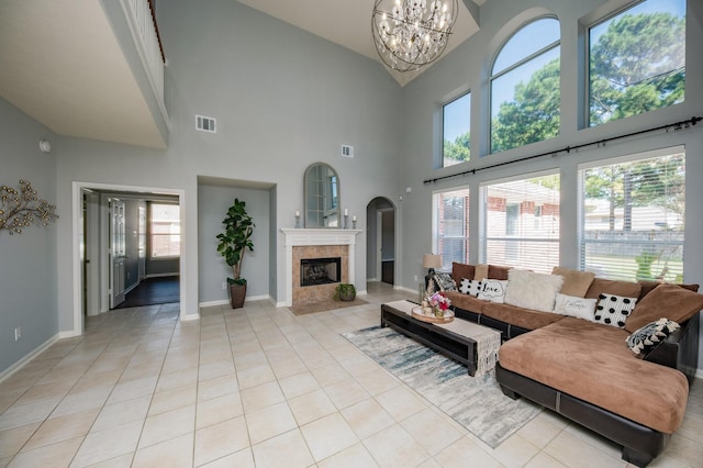 living room featuring a notable chandelier, a towering ceiling, and a wealth of natural light