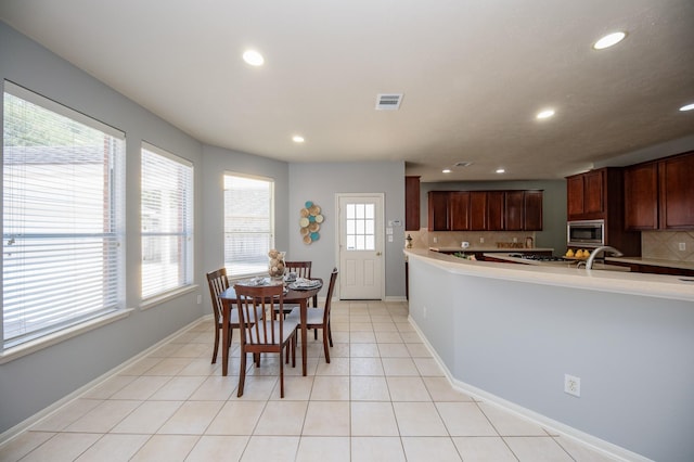 tiled dining area featuring plenty of natural light and sink