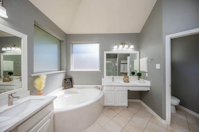 bathroom with tile patterned flooring, vaulted ceiling, toilet, a bathtub, and vanity