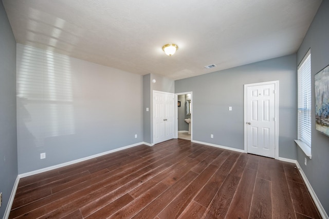 empty room with dark hardwood / wood-style flooring