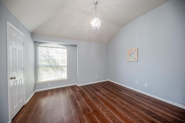 spare room with a notable chandelier, dark hardwood / wood-style flooring, and lofted ceiling