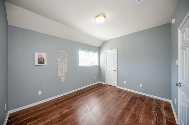 unfurnished bedroom featuring dark hardwood / wood-style flooring and vaulted ceiling