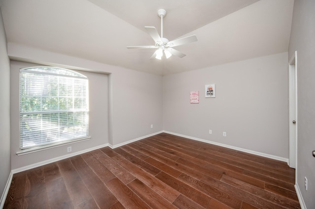 spare room featuring ceiling fan, dark wood-type flooring, and vaulted ceiling