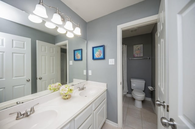 bathroom featuring tile patterned floors, vanity, and toilet