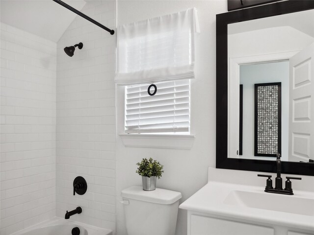 full bathroom with vanity, tiled shower / bath combo, vaulted ceiling, and toilet