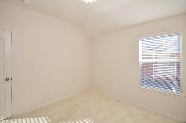 empty room with light carpet and vaulted ceiling