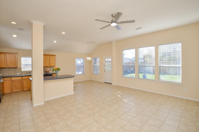 kitchen with a healthy amount of sunlight, lofted ceiling, light tile patterned floors, and decorative columns