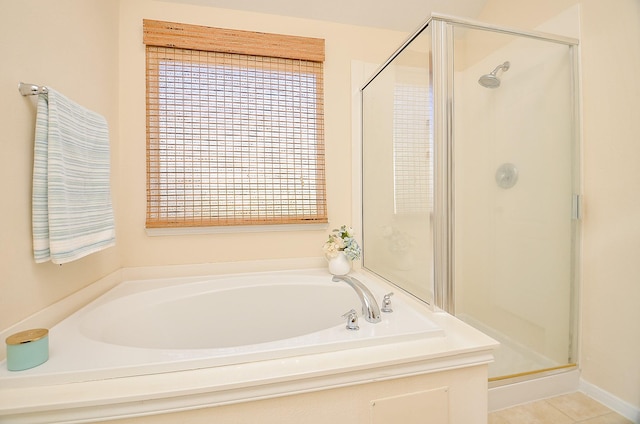 bathroom with tile patterned flooring and shower with separate bathtub