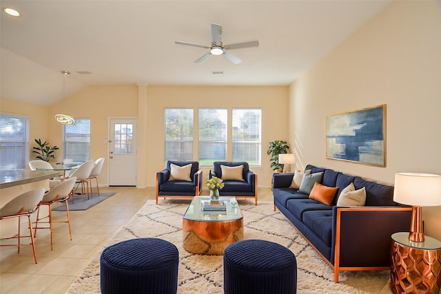 living room with ceiling fan, light tile patterned floors, and vaulted ceiling