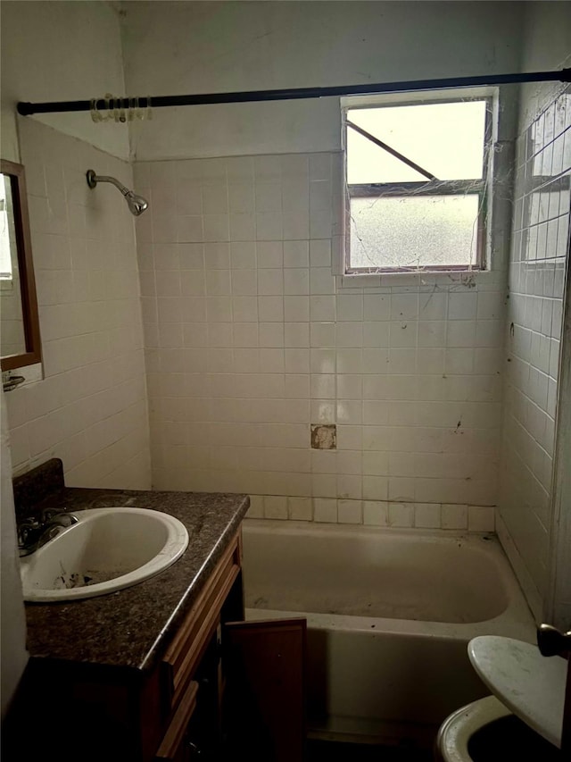 full bathroom featuring tiled shower / bath, vanity, and toilet