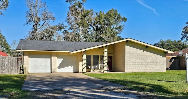 mid-century inspired home with brick siding, concrete driveway, an attached garage, fence, and a front yard