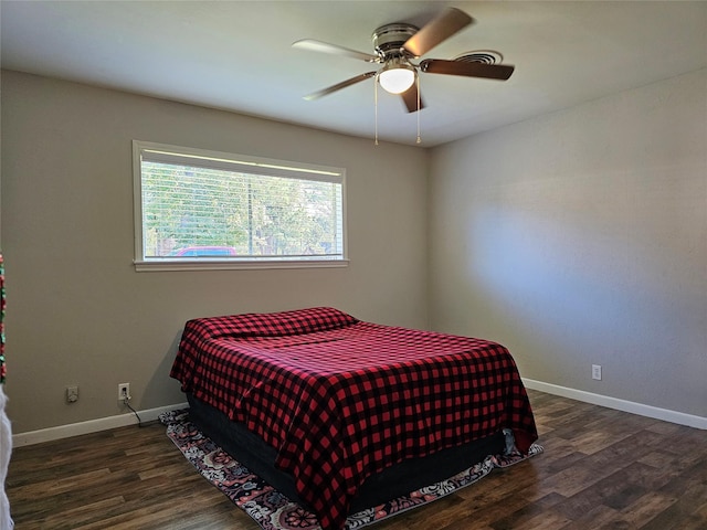 bedroom with a ceiling fan, baseboards, and wood finished floors