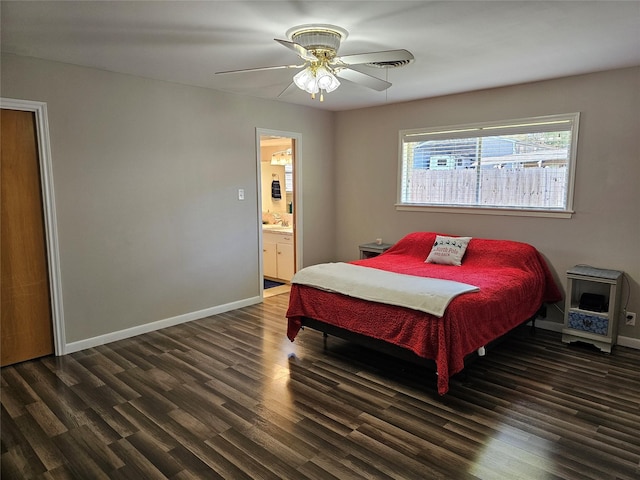 bedroom featuring a ceiling fan, a sink, ensuite bath, wood finished floors, and baseboards