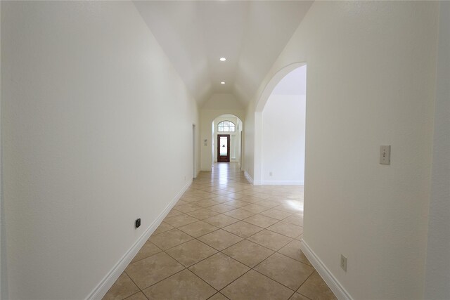 hall with light tile patterned floors and vaulted ceiling