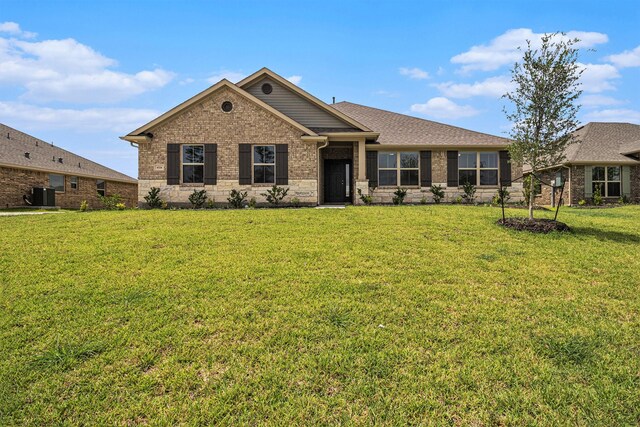 view of front of house with a front yard and central AC