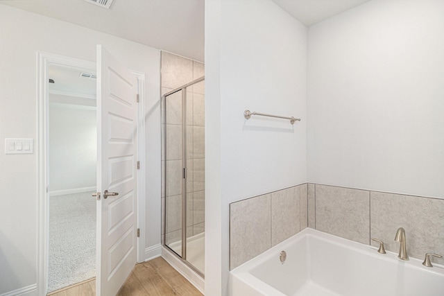 bathroom featuring shower with separate bathtub and hardwood / wood-style flooring