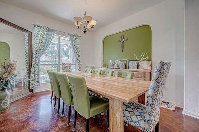 dining room featuring concrete flooring and an inviting chandelier