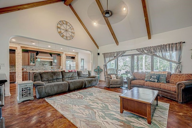 living room with beam ceiling, ceiling fan, and high vaulted ceiling