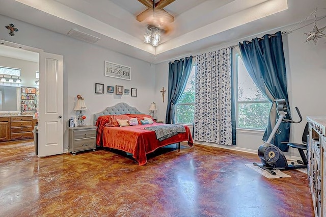 bedroom with ceiling fan, a raised ceiling, and concrete flooring