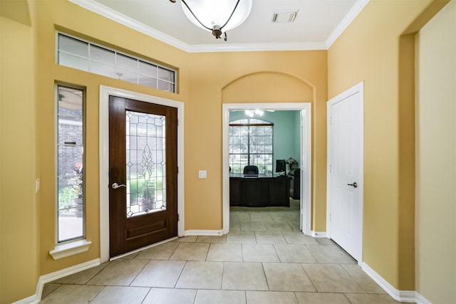 entryway featuring a healthy amount of sunlight, ornamental molding, and light tile patterned floors