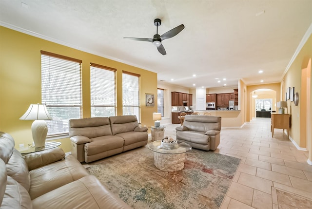 tiled living room featuring crown molding and ceiling fan