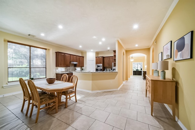 dining room featuring light tile patterned floors, plenty of natural light, and crown molding