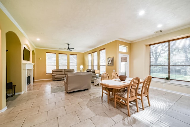 tiled dining space featuring ceiling fan and crown molding