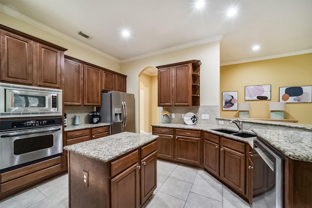 kitchen with crown molding, sink, a kitchen island, and stainless steel appliances