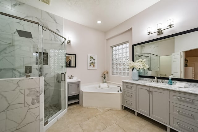 bathroom featuring plus walk in shower, vanity, and tile patterned floors