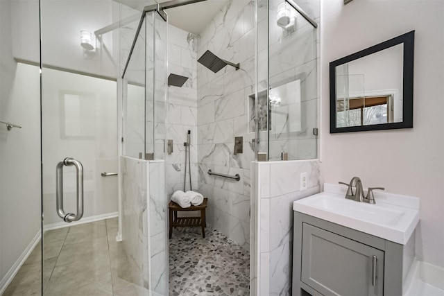 bathroom with tile patterned floors, a shower with door, and vanity