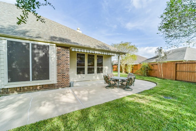 back of property with a yard and a patio