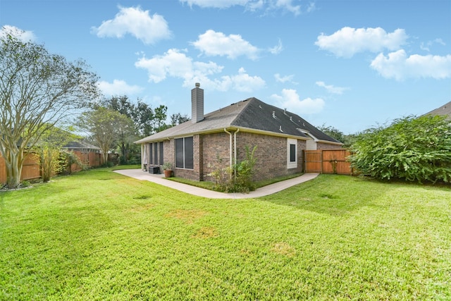 rear view of house featuring a yard and a patio