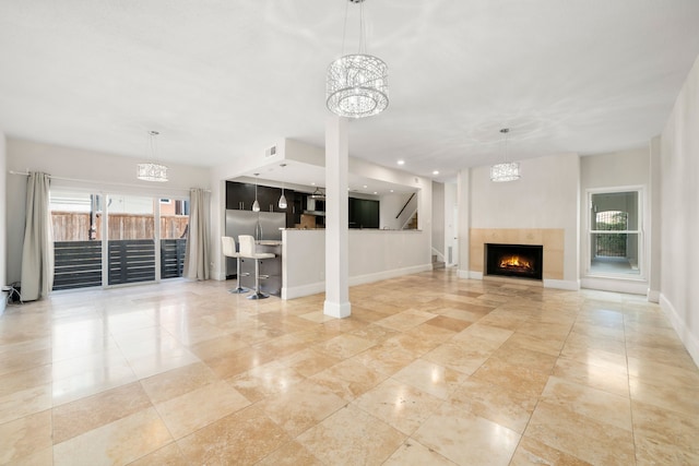 unfurnished living room with a fireplace and an inviting chandelier