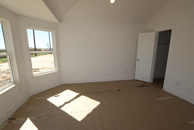 interior space featuring baseboards and lofted ceiling