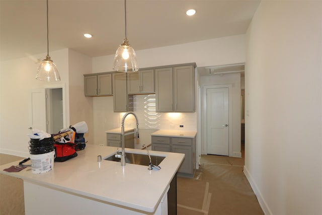 kitchen with a sink, recessed lighting, a center island with sink, and gray cabinets