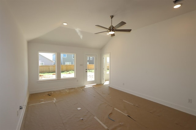 empty room with lofted ceiling, recessed lighting, baseboards, and ceiling fan