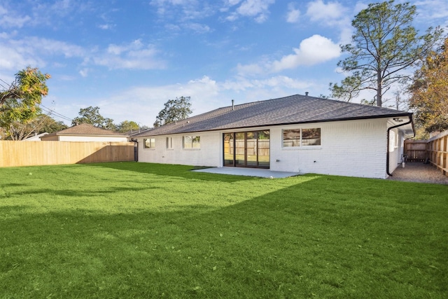 back of property with a lawn and a patio area