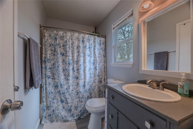 bathroom featuring a shower with curtain, vanity, and toilet