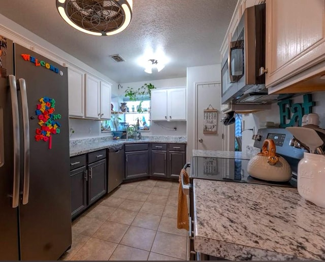 kitchen with white cabinets, sink, appliances with stainless steel finishes, and a textured ceiling