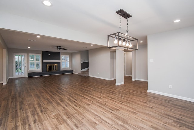 unfurnished living room featuring ceiling fan, a fireplace, and hardwood / wood-style flooring