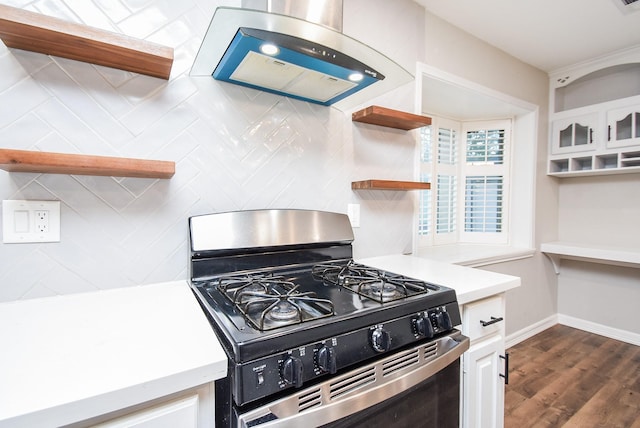 kitchen with stainless steel range with gas cooktop, dark hardwood / wood-style floors, tasteful backsplash, island range hood, and white cabinetry