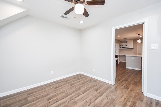 empty room with ceiling fan and hardwood / wood-style floors