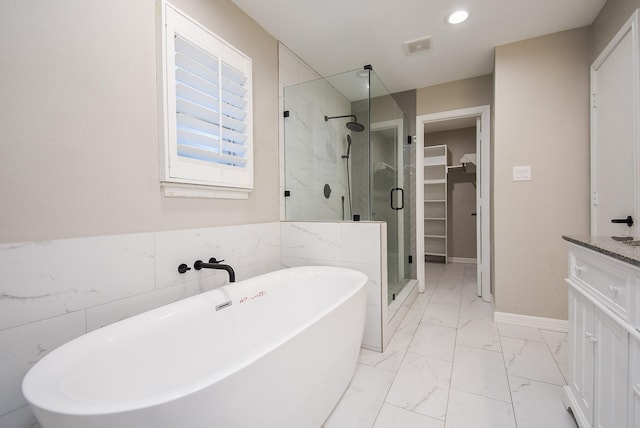 bathroom with vanity, tile walls, and plus walk in shower