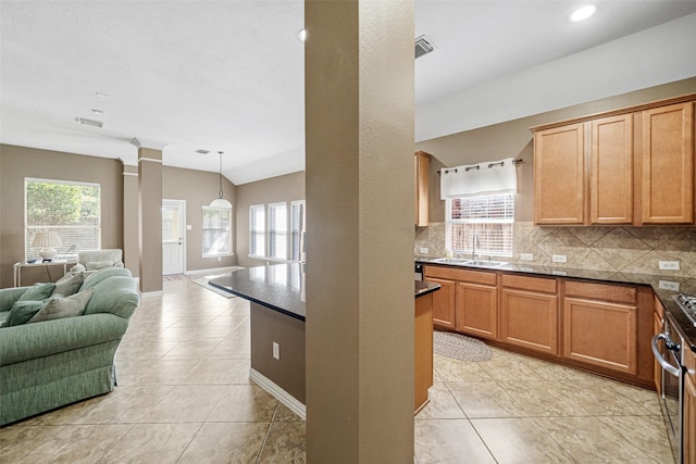 kitchen with light tile patterned flooring, sink, pendant lighting, and backsplash