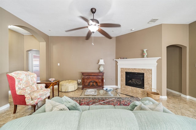 tiled living room with ceiling fan and a premium fireplace