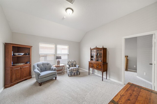 sitting room featuring light colored carpet and vaulted ceiling