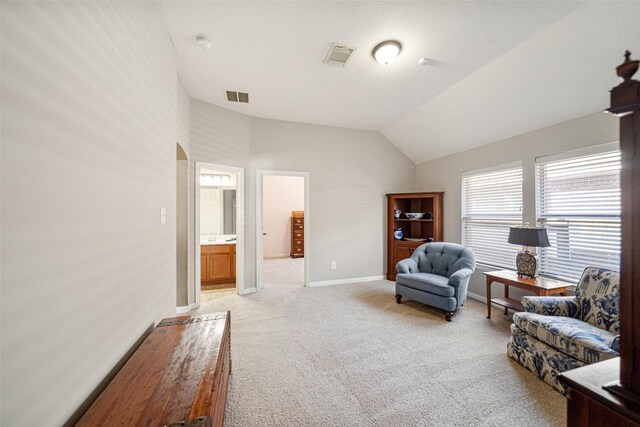 sitting room featuring vaulted ceiling and light colored carpet