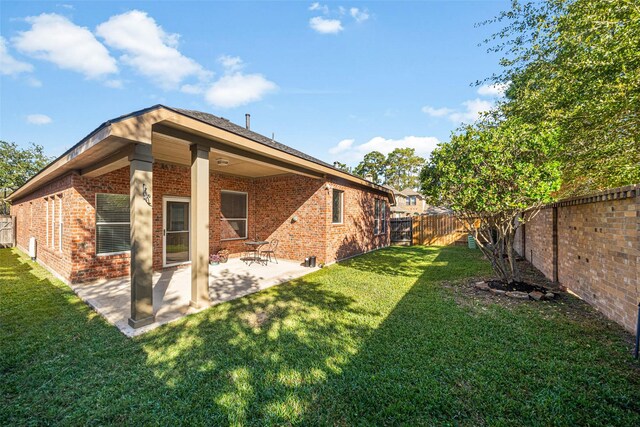 back of house with a yard and a patio